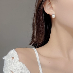 Gros plan d'une boucle d'oreille en perle d'eau douce baroque irrégulière sur modèle