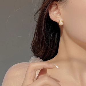 Boucles d'oreilles perles d'eau douce baroques dorées portées dans un style vintage