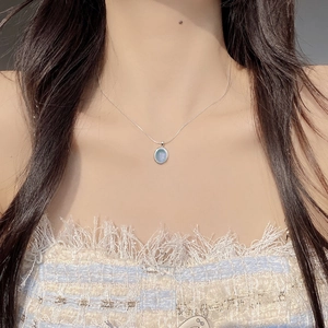 Elegant S925 sterling silver necklace with oval natural aquamarine pendant on a female model