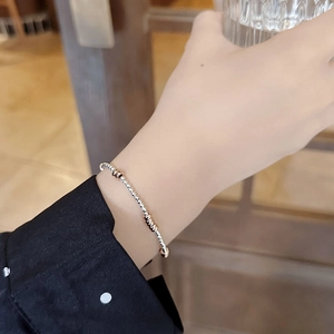 Detail of 925 sterling silver beaded bracelet with rose gold accents on a wrist