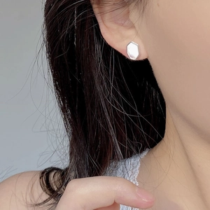 Close-up of geometric S925 sterling silver hexagonal earrings with mother of pearl inlay