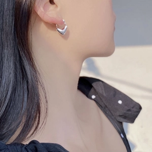 S925 sterling silver heart hoop earrings with polished finish shown on female model