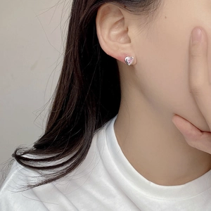 Elegante S925 Silber Herz Ohrstecker mit rosa Zirkonia getragen von einem weiblichen Model