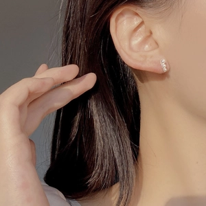 Close-up of triple pearl drop earrings in S925 silver on model's ear showing luster