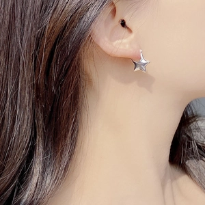 Minimalist S925 sterling silver 3D star hoop earrings shown worn on a model ear