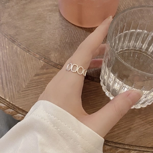 Détail d'une bague chaîne minimaliste en argent sterling S925 portée sur un doigt élégant