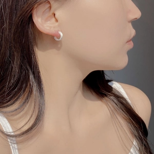 Close-up of minimalist 925 sterling silver hoop earrings with a brushed matte texture