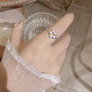 Close-up of a minimalist 925 sterling silver hollow flower ring worn on the finger