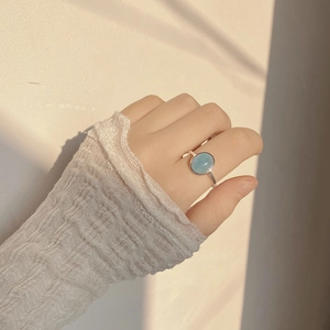 Close-up of S925 sterling silver ring with oval aquamarine on model's finger