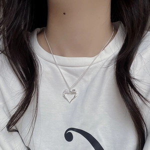 Detailed view of S925 sterling silver hollow heart pendant with angel wings on a model
