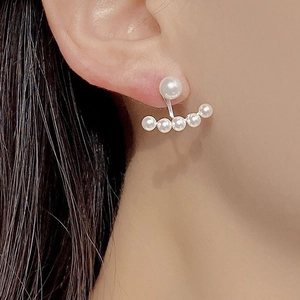 Close-up of vintage pearl earrings with 925 silver curved five-pearl drop on model