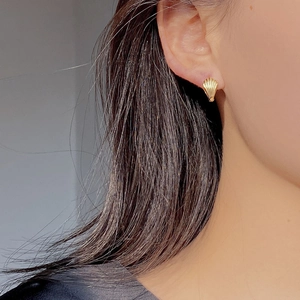Elegant gold shell stud earrings in S925 sterling silver worn by a model on the ear