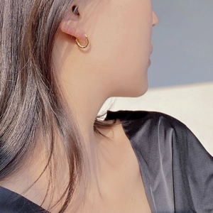 Close-up of minimalist gold-plated sterling silver hoop earring worn by a model