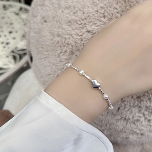 Détail du bracelet cœur en argent massif S925 avec perles naturelles sur le poignet