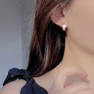 Elegant S925 sterling silver shell earrings with textured metallic finish on model