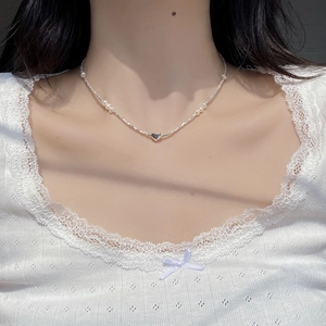 Detailed view of S925 silver heart pendant necklace with natural pearls on a model