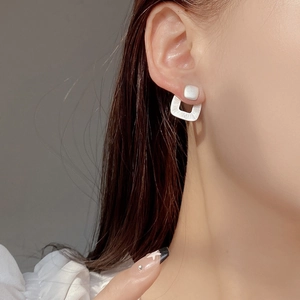 Close-up of S925 sterling silver geometric square earrings with matte brushed finish texture