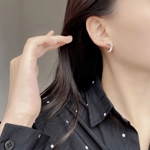 Close-up of elegant S925 sterling silver crescent moon earrings worn by a model