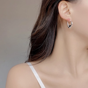 Close-up of minimalist S925 sterling silver U-shaped hoop earring on model side profile