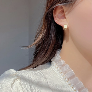 Minimalist S925 sterling silver huggie earrings with vertical striped texture on model