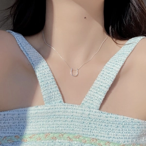 Gros plan sur le collier fer à cheval en argent S925 avec pendentif en U et chaîne serpent
