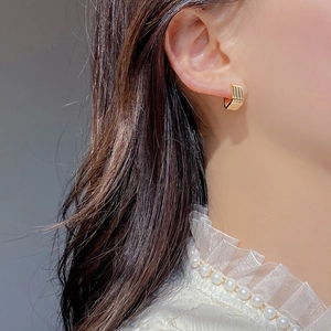 Detailed view of gold square S925 sterling silver hoop earrings with vertical stripe texture