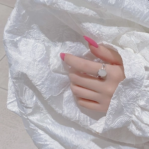 Detailed view of an oval moonstone ring with intricate hollow silver band design