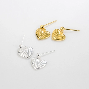 Detailed view of gold and silver S925 sterling silver heart earrings with wavy texture