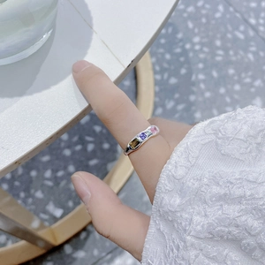 Irregular silver wave ring featuring three square multi-color zircons on a model hand
