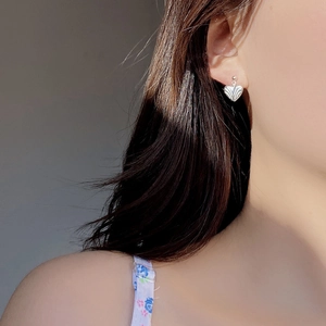 Close-up of S925 sterling silver heart stud earring with textured ripple finish on ear