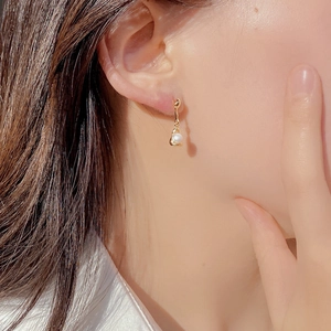 Close-up of elegant S925 silver pearl drop earring on model with golden finish