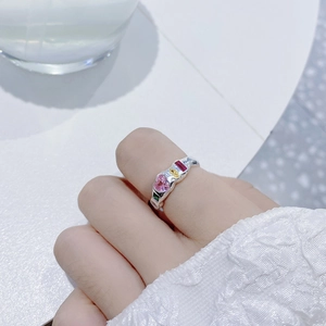 Macro shot of silver ring with irregular texture and four colorful zircon gemstones