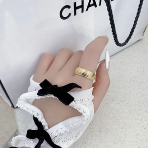 Close-up of golden multi-layer textured ring styled with vintage white lace gloves
