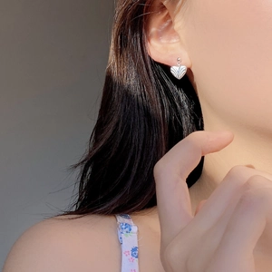 S925 sterling silver heart stud earrings featuring radiant textured pattern on model