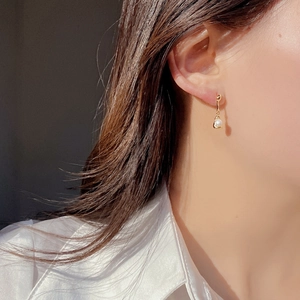 Detailed view of elegant S925 silver gold-plated earrings with natural white pearl on model