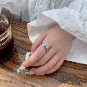 Detailed view of an irregular S925 silver ring with colorful zircons on a model's finger