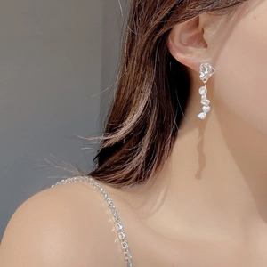 Close-up of S925 sterling silver drop earrings with natural baroque pearls on a model