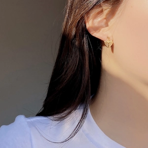 Macro detail of gold S925 silver heart stud earrings with vertical textured ripples