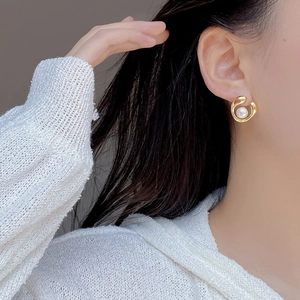 S925 sterling silver gold earrings featuring a large freshwater pearl on a female model