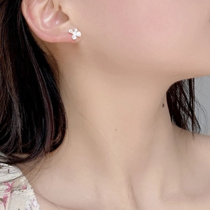 Détail macro de boucles d'oreilles fleurs de gardénia en argent S925 portées par modèle