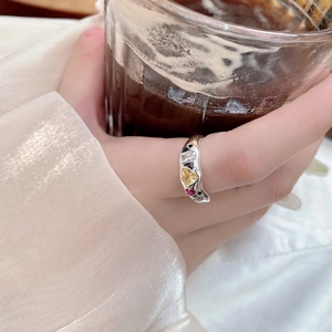 Detail of silver S925 ring with colorful zircon stones on model holding a cup