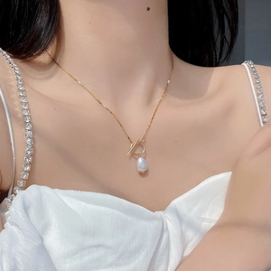 Close-up of S925 silver golden chain necklace with natural Baroque pearl and OT toggle clasp