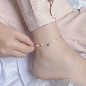 Gros plan d'une chaîne de cheville en argent S925 avec pendentif scintillant en zircon rose