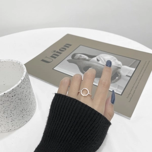 Close-up of minimalist S925 sterling silver hollow round ring on finger in a chic setting