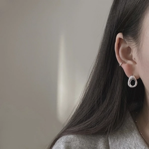 Close-up of 925 sterling silver hollow water drop earrings and minimalist ear cuff set