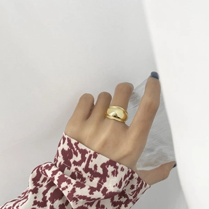 Minimalist wide S925 sterling silver gold-plated ring on hand with glossy finish