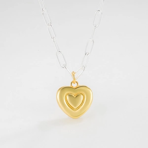 Détail macro de la chaîne trombone bicolore avec un pendentif cœur 3D à double couche
