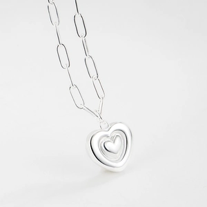 Détail du pendentif cœur superposé en argent 925 sur une chaîne à maillons trombone