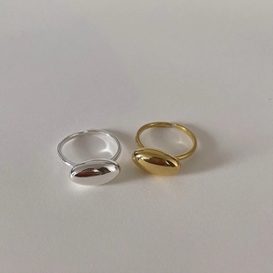 Detailed view of silver and gold oval rings with adjustable bands and mirror finish
