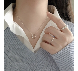 Detail of minimalist S925 silver irregular circle pendant necklace with chic silver rings